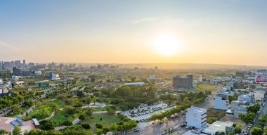 Taichung City, Tayvan - 13 Mayıs 2020: Taichung Central Park. Günbatımında gökyüzü arkaplanı renkli modern şehir silueti. Xitun Bölgesi, Shuinan Ekonomi ve Ticaret Bölgesi. Eski Shuinan Havaalanı