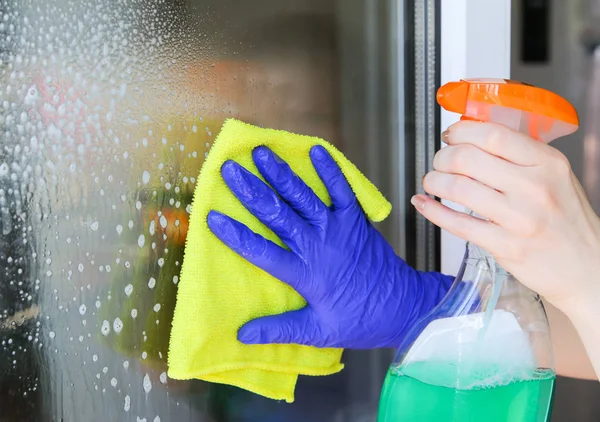 Mujer limpiando una ventana — Foto de Stock
