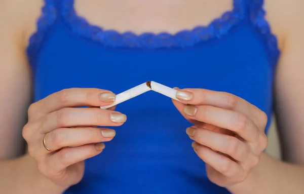 A girl breaks a cigarette.