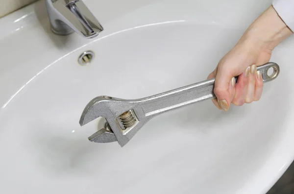 A woman is repairing a water tap. — Stock Photo, Image