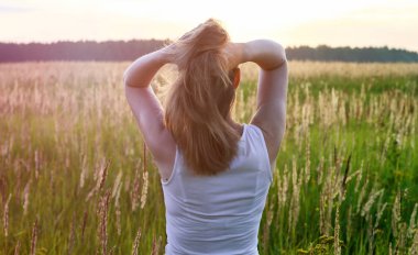 Gün batımında, alandaki güzel sarışın Bayan mutlu hisseder