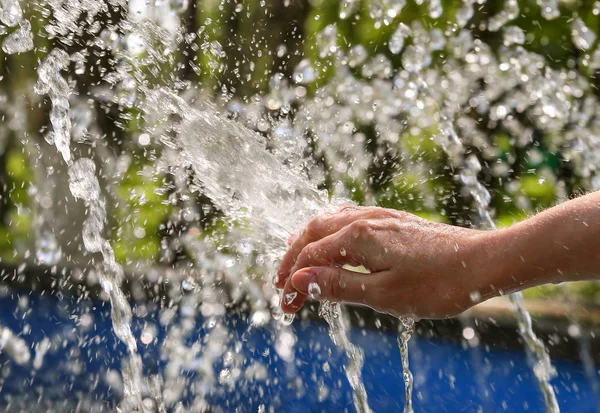 Woman\'s hand and water spray