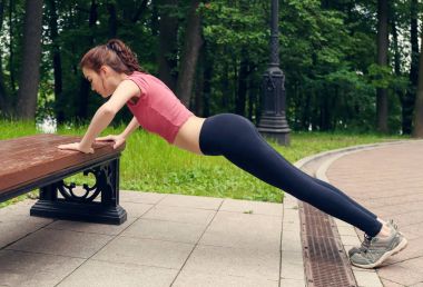 Profil görünümü itme yapıyor bir genç kadının ups bir parkta bankta