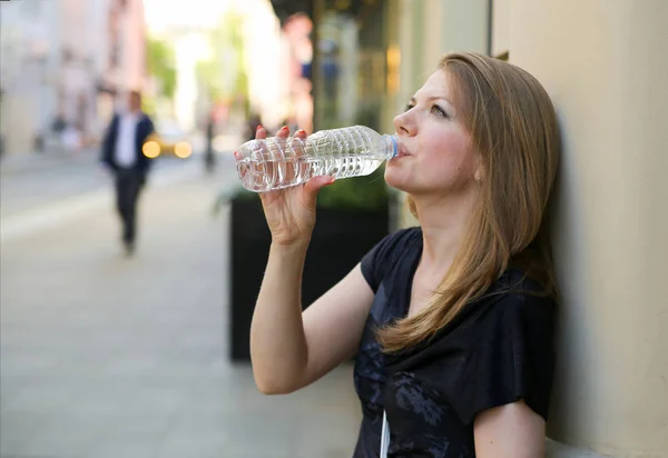 Женщина пьет воду из пластиковой бутылки Стоковое Изображение