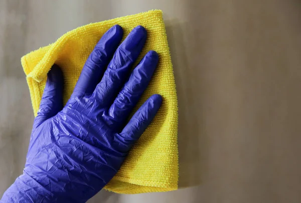 Mujer limpiando una ventana con un paño amarillo — Foto de Stock