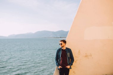 Genç adam düşünüyor onun arkasında hayatı hakkında güzel yeni bahar ve deniz gördüm