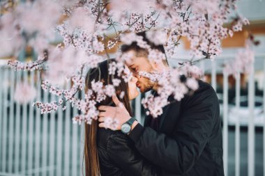 Bir çiçek açan altında güzel romantik çift öpüşme ağaç bahar