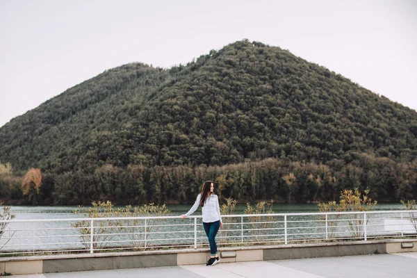 Joven Está Lado Hermoso Lago Parte Atrás Hay Una Colina — Foto de Stock