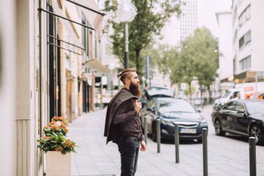 Sakallı genç adam ofise gider. arkasında bir klasik tarzı jacet var