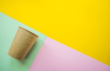 Kağıt bardak renkli arka plan üzerinde.