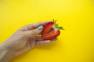 Kadının elinde bir çilek.