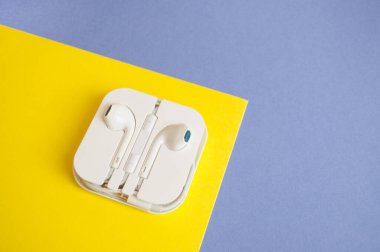 Beyaz plastik bir kutuda kablosuz kulaklıklar..