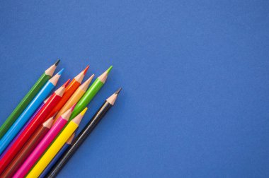 Mavi arkaplanda renkli kalemler.