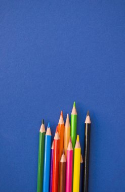 Mavi arkaplanda renkli kalemler.