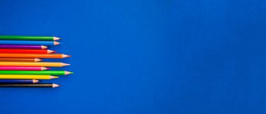 Mavi arkaplanda renkli kalemler.