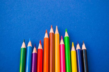 Mavi arkaplanda renkli kalemler.