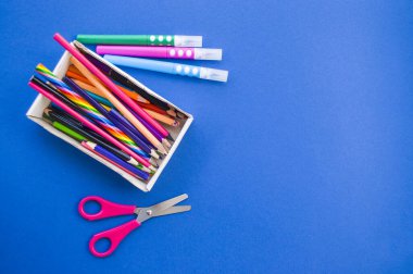 Mavi arkaplanda renkli kalemler.