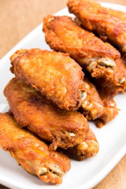 kızarmış tavuk kanatları beyaz plaka üzerinde