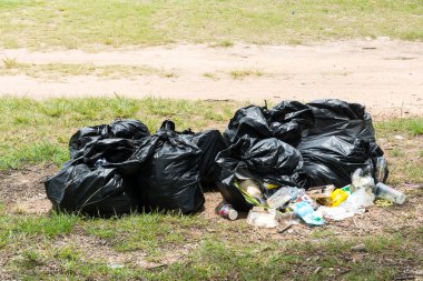 Kirli, yol kenarındaki çöp üzerinde tam çöp torbası