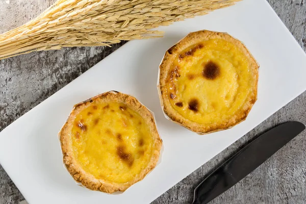 Egg tart or portuguese egg tart wit knife on wooden