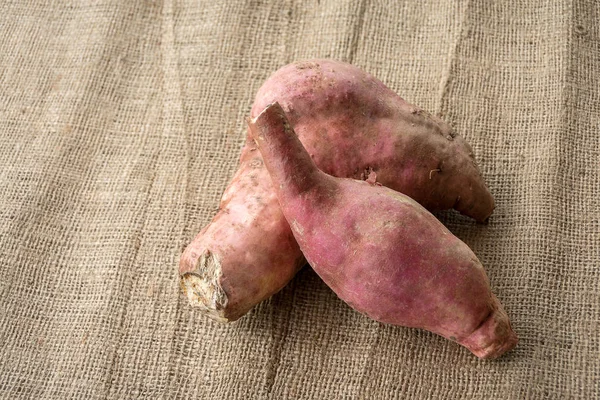 Raw sweet potatoes on table