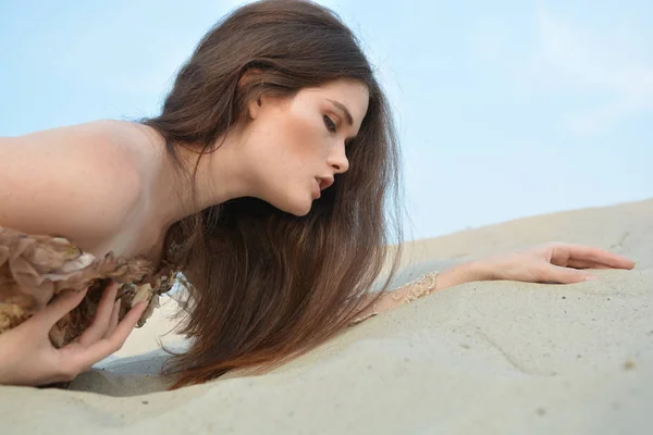 Portrait d'une élégante jeune fille qui repose sur le sable — Photo
