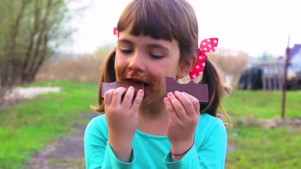 甘い物好きの子供がチョコレートを食べる — ストック動画