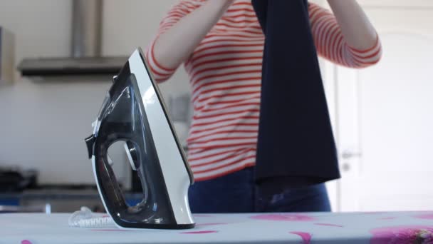 Woman Doing Homework Ironing and folding Clothes On Ironing Board Iron At Home In Interior. — Stock Footage Woman Doing Homework Ironing and folding Clothes On Ironing Board Iron At Home In Interior. Stock Video