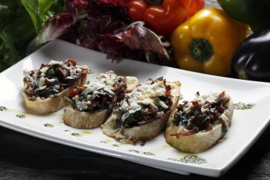 Vejetaryen Bruschetti beyaz plaka üzerinde