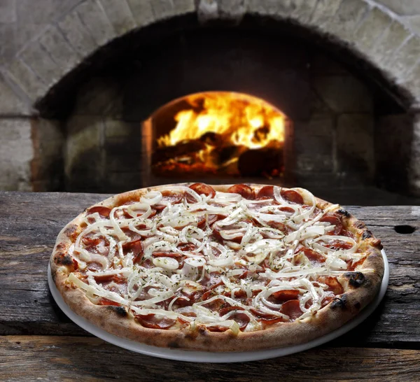 Delicious pizza in the wood-fired oven — Stock Photo, Image