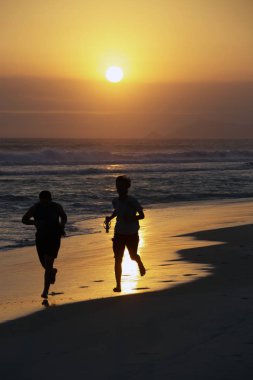 Sunset beach, Rio de Janeiro üzerinde yürüyen insanlar