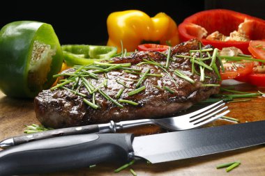 Çatal ve bıçak, ahşap tahta üzerinde kavrulmuş fileto görünümü kapatın