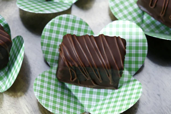 Doces de chocolate em papel verde embrulho — Fotografia de Stock