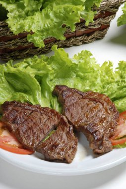 Domates ve salata yaprakları ile dilimlenmiş Picanha