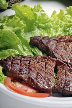 Domates ve salata yaprakları ile dilimlenmiş Picanha