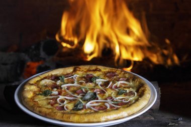 Pizza kurutulmuş domates ve fesleğen yaprakları