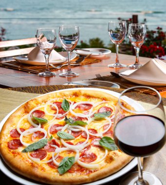 Pepperoni pizza ve kırmızı şarap, plajda pizza.