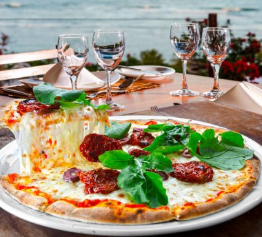 Pizza dilimi erimiş peynir, plajda pizza.