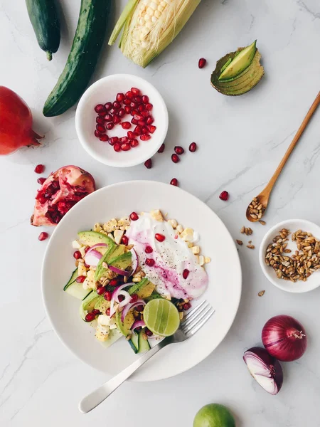 Beyaz kase salata avokado, tatlı mısır, nar, salatalık, kırmızı soğan, limon, Yunan yoğurt ve ayçiçeği tohumu ile hizmet