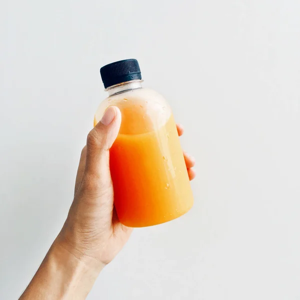 Holding juice bottle — Stock Photo, Image