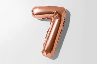 7 numara, 7 numaralı altın folyo balonu kırpma yolu olan beyaz bir arkaplanda izole edildi.