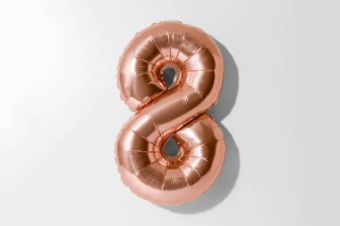 8 numara, 8 numaralı altın folyo balonu kırpma yolu olan beyaz bir arkaplanda izole edildi.