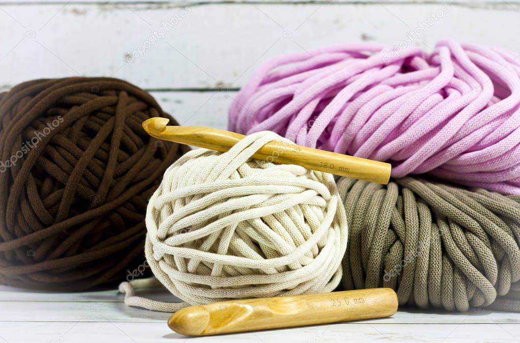 Yarns in basket with crochet hooks in harmonious colors. knitting, crocheting supplies.