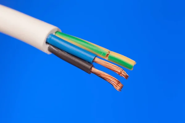 Närbild av en elektrisk kabel på en blå bakgrund — Stockfoto