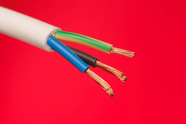 Close-up de um cabo elétrico em um fundo vermelho — Fotografia de Stock