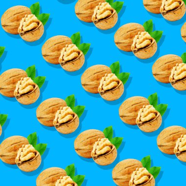 Ceviz yaprağı deseni üzerinde pastel mavi arka plan ile. Çok az meyve kavramı.