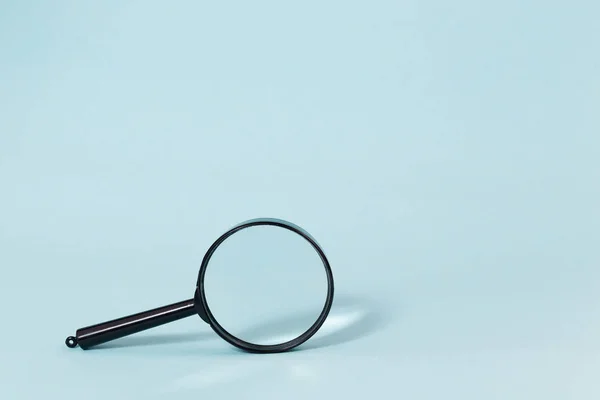 Magnifying glass on a pastel blue background — Stock Photo, Image