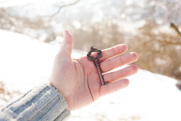 Hand holding a vintage key, winter time. — Stock Photo, Image