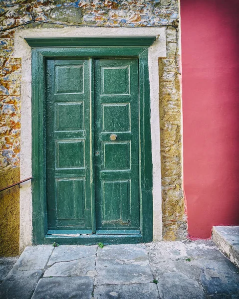 Taş duvar ev koyu pembe kısmı ile yeşil kapı — Stok fotoğraf