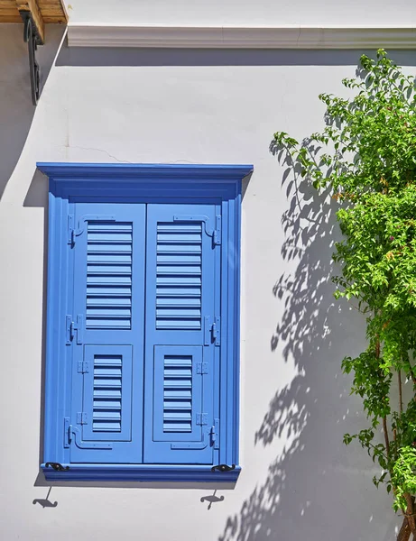 Blue shutters window on white wall — Stock Photo, Image